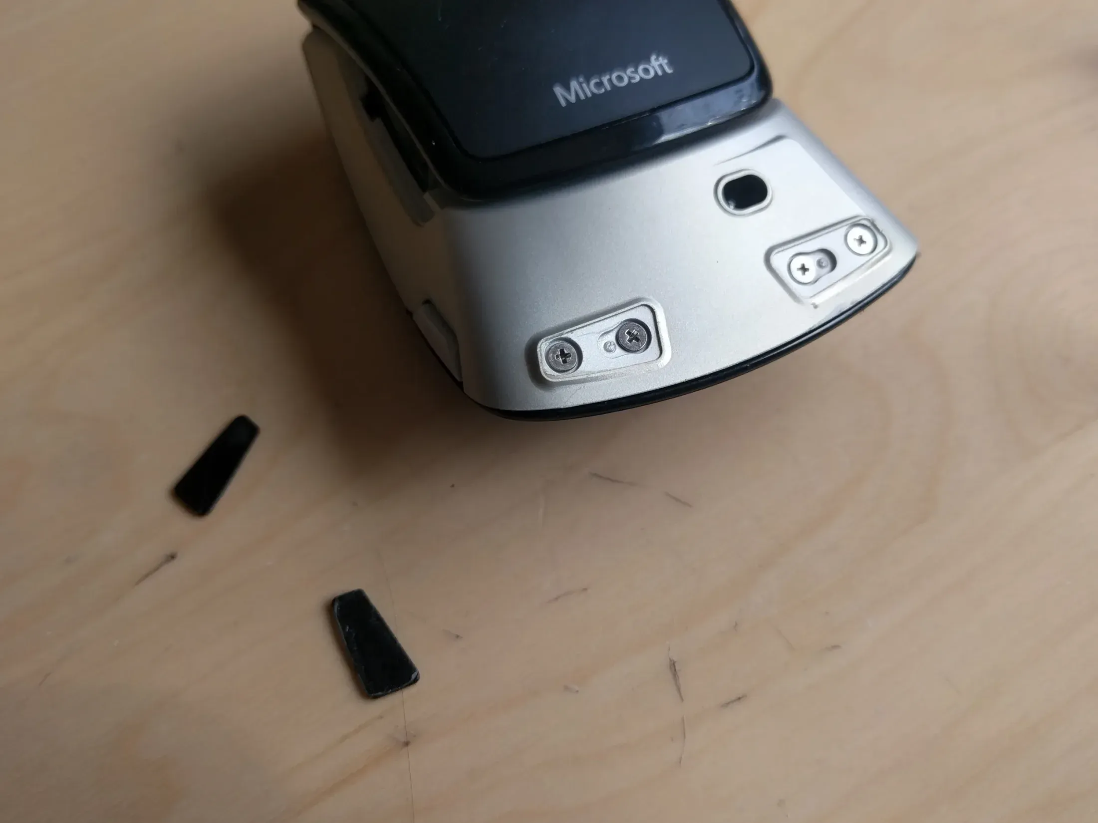 Battery bay sticker lifted to reveal hidden screws and T6 fastener